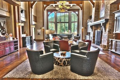 Cozy lodge style living room featuring a stone fireplace by the large windows at Hotel Park City Autograph Collection
