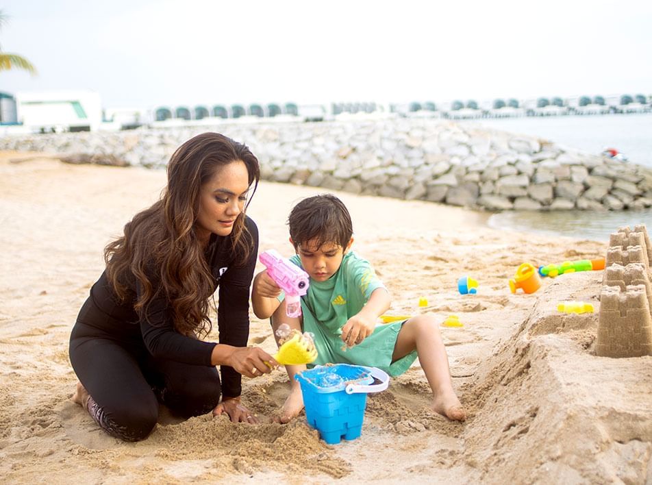 Mother and son building a sand castle - Lexis Hibiscus