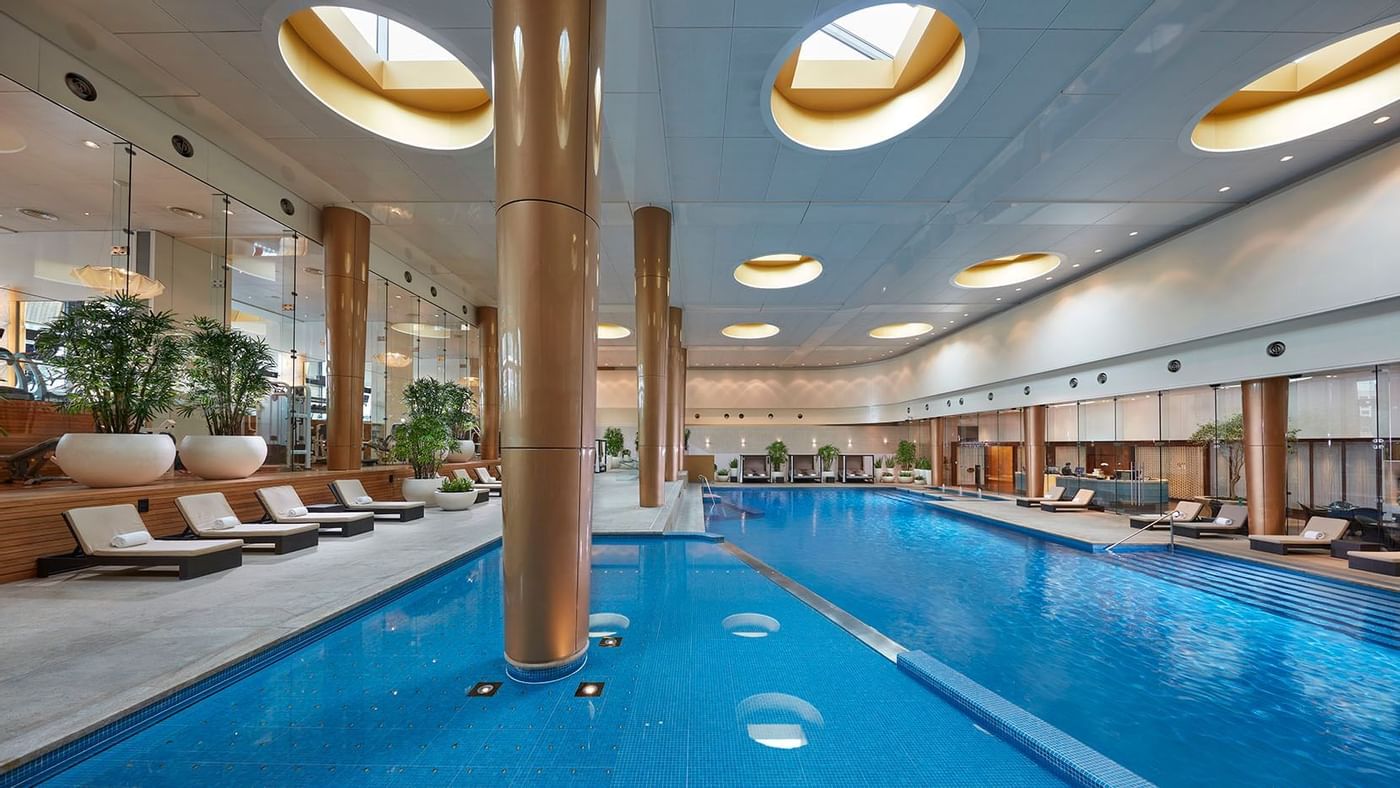 Indoor pool with lounge chairs at Crown Hotels