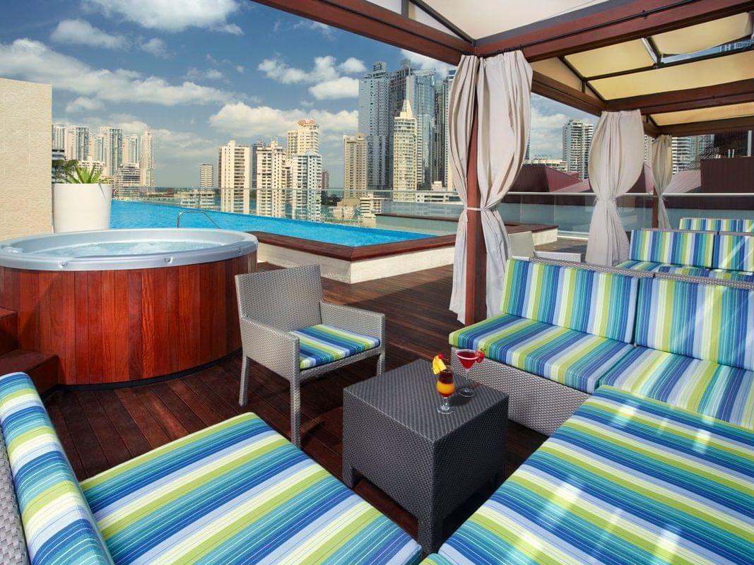Acogedoras sillas arregladas en Float Bar con piscina infinita y jacuzzi en Megapolis Hotel Panamá