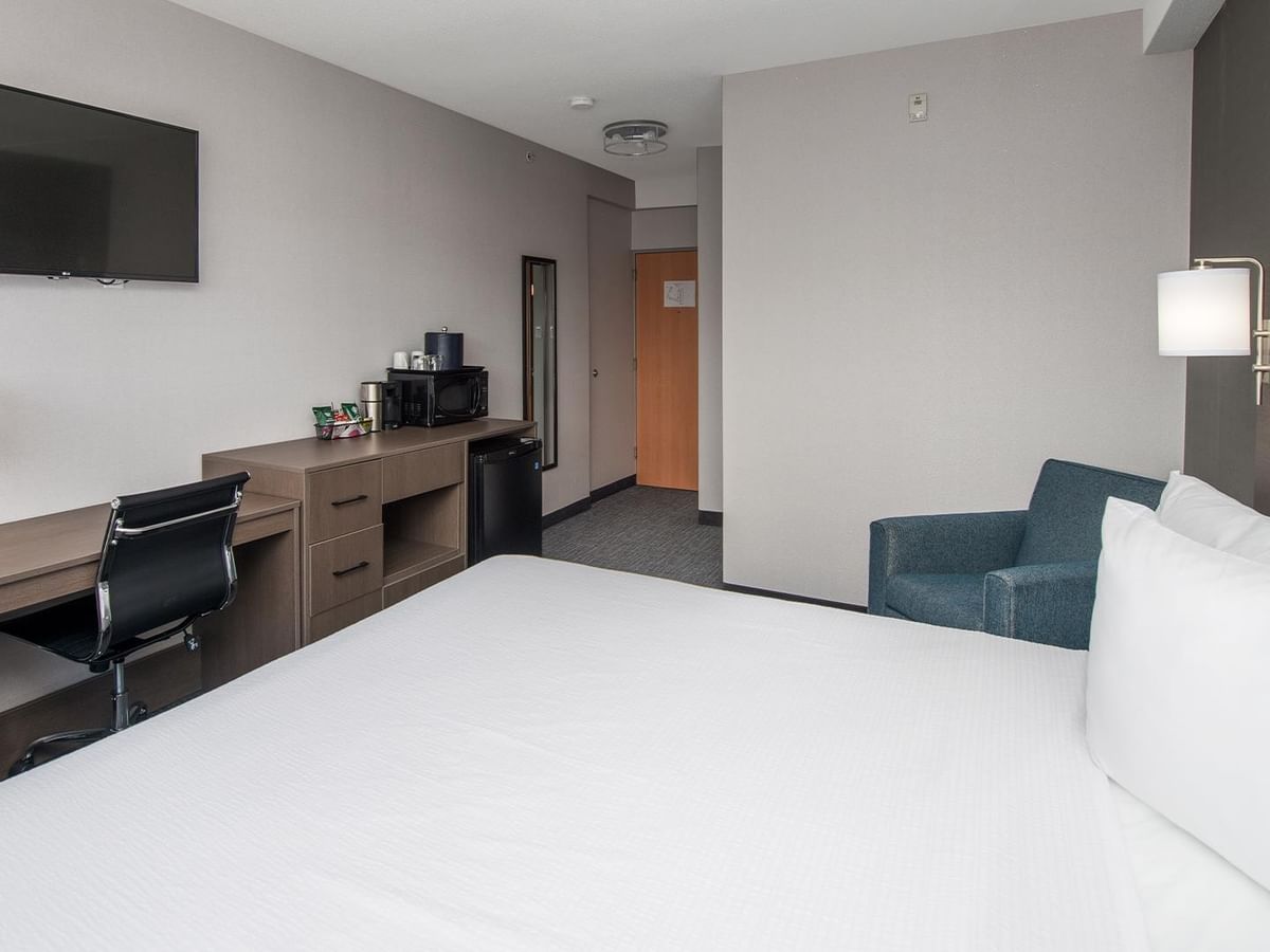 King-sized bed, desk, microwave, and armchair.