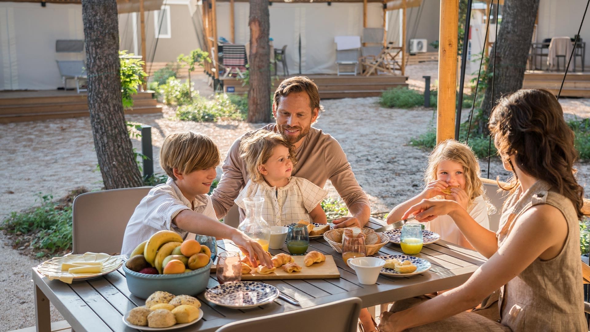 Family enjoying a meal in the outdoor open area at Falkensteiner Premium Camping Zadar