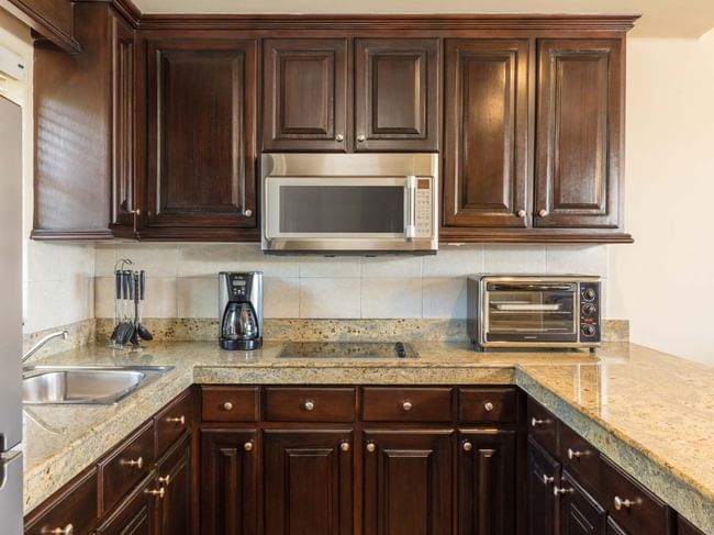 Kitchen with wood cabinets, microwave and coffee maker in the One Bedroom Villa at Hacienda Del Mar Los Cabos.