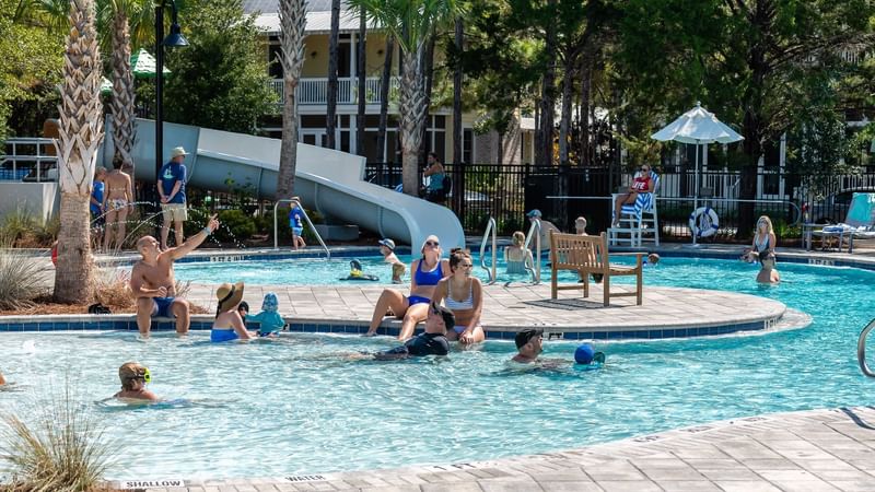 People swimming & sunbathing in a pool at WaterColor Inn