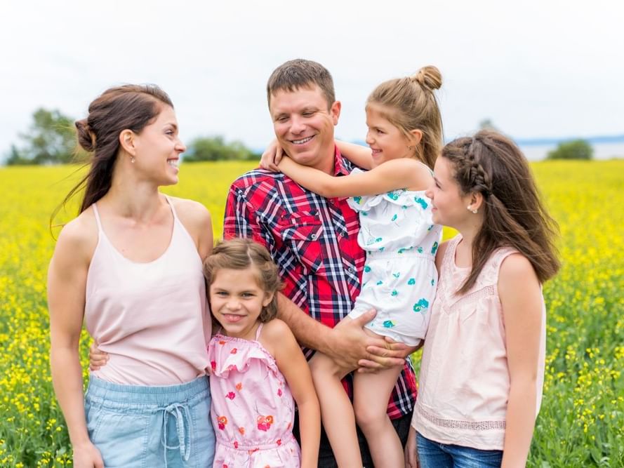 Family standing in a blooming yellow field near Lake Buena Vista Resort Village & Spa