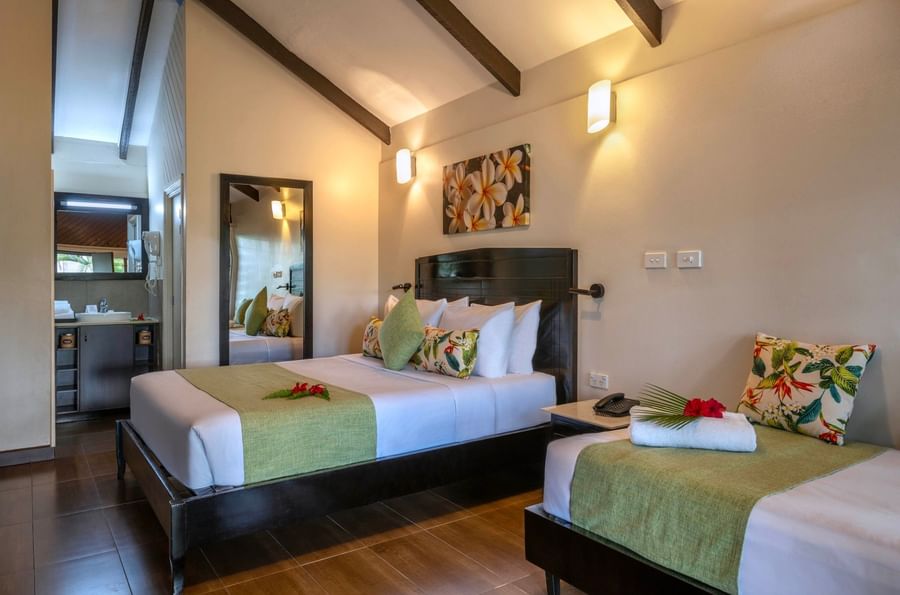 Two beds with floral decor and tropical touches in a room at Tokatoka Resort near Fiji International Airport.