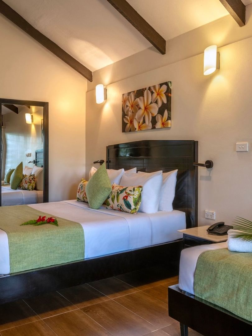 Two beds with tropical decor in a Deluxe Villa at Tokatoka Resort in Nadi