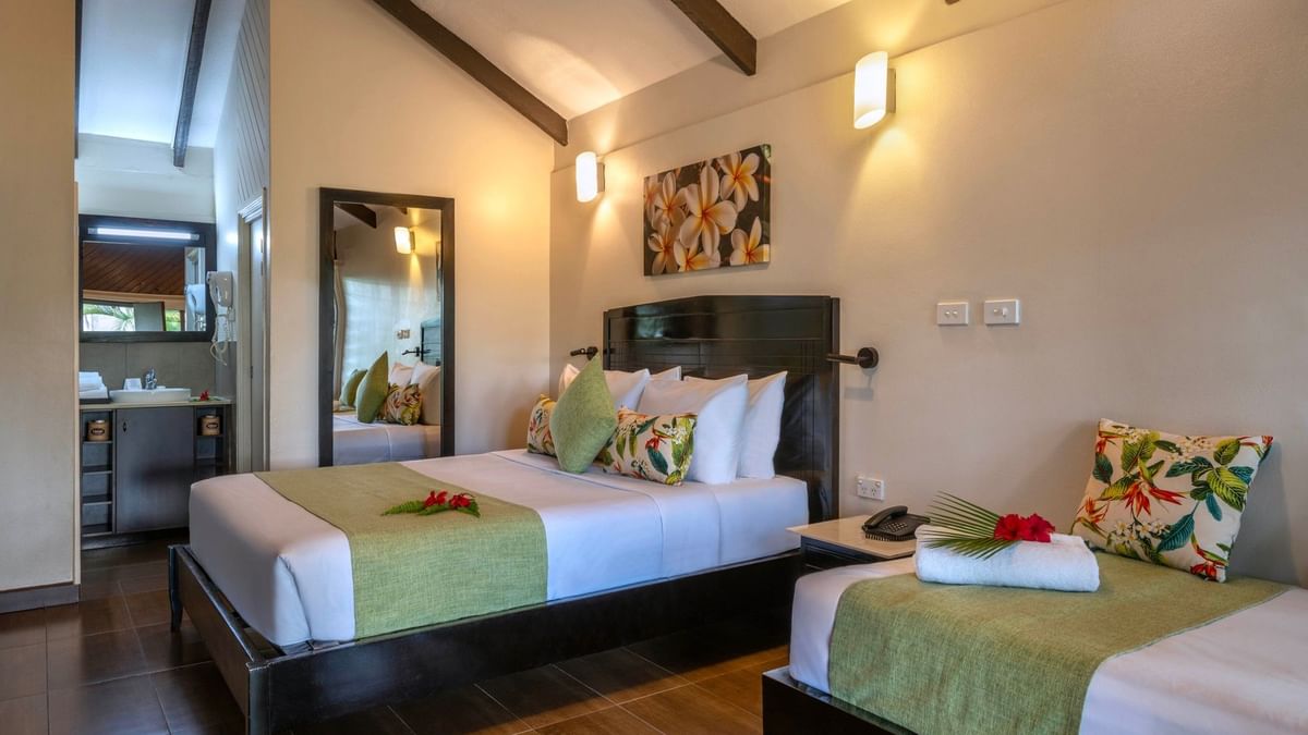 Two beds with tropical decor in a Deluxe Villa at Tokatoka Resort in Nadi.