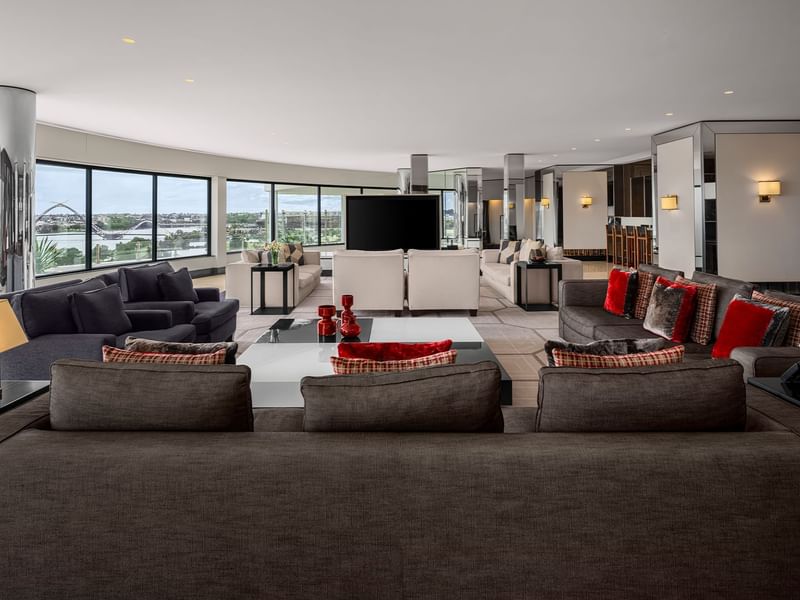 Modern living room with dark sofas, TV, and panoramic windows in Two Bedroom Penthouse at Crown Metropol Perth
