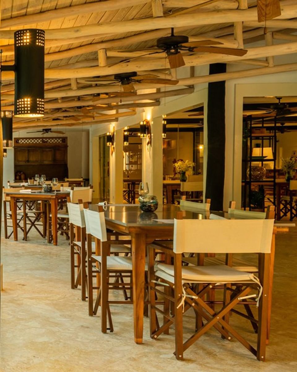Dining area of Garden Restaurant with wood furniture and column lighting at Hotel La Casita by The Hub, a Higuey restaurant