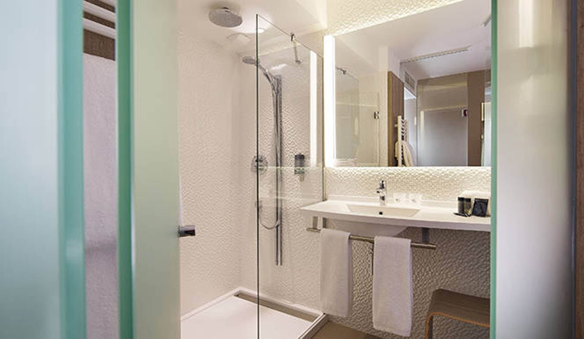 Bathroom vanity & shower in a room at Oceania Nantes Aéroport