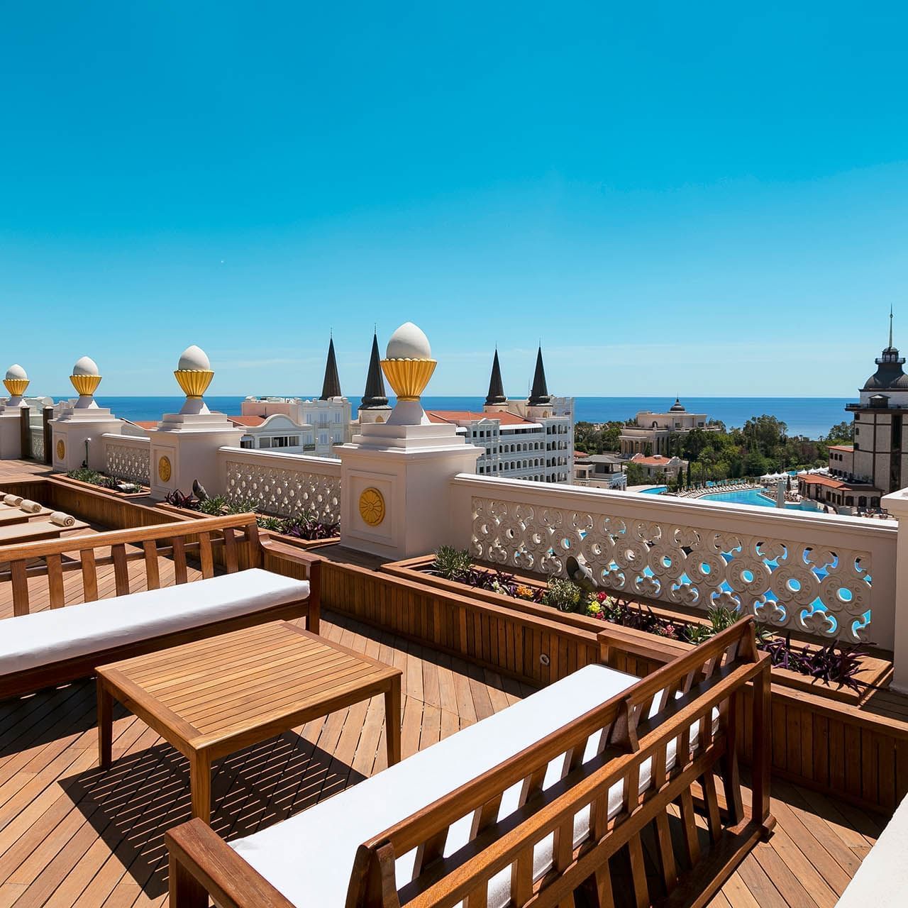 Titanic Mardan Palace'ın King Suite terasından güneşli bir günde denize bakan şezlong ve lounge alanı