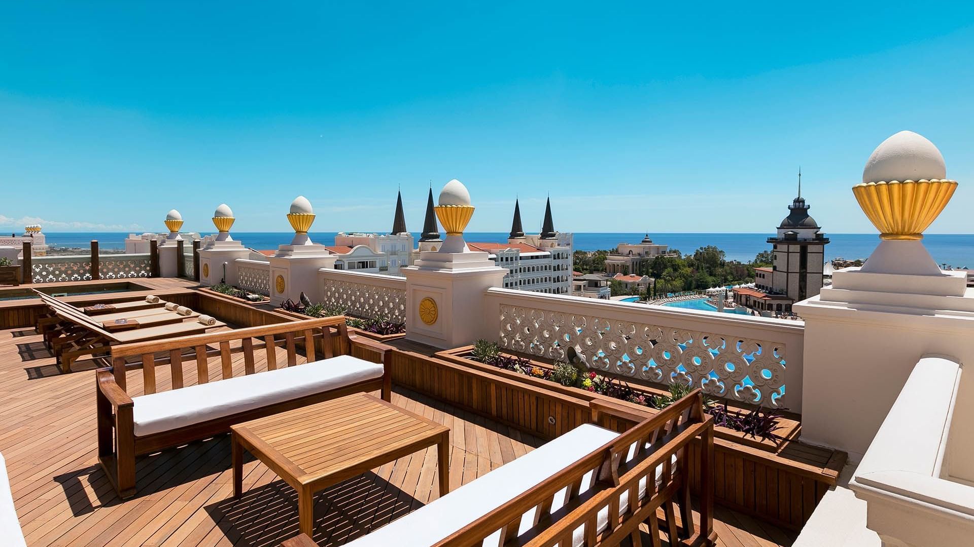 Titanic Mardan Palace'ın King Suite terasından güneşli bir günde denize bakan şezlong ve lounge alanı