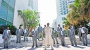 Group of men in suits posing around a groom at Diplomat Beach Resort