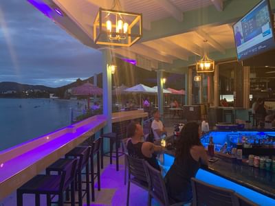 Guests at Beach Bar at Emerald Beach Resort, lively evenings at a St. Thomas resort with beach bar and Caribbean restaurant