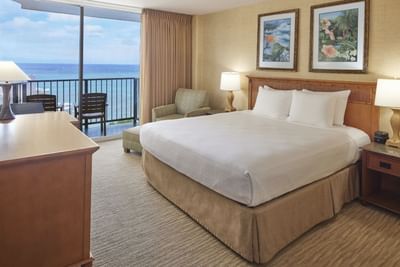 King-size bed with a single sofa & the balcony view in Partial Ocean View at Waikiki Resort Hotel by Sono