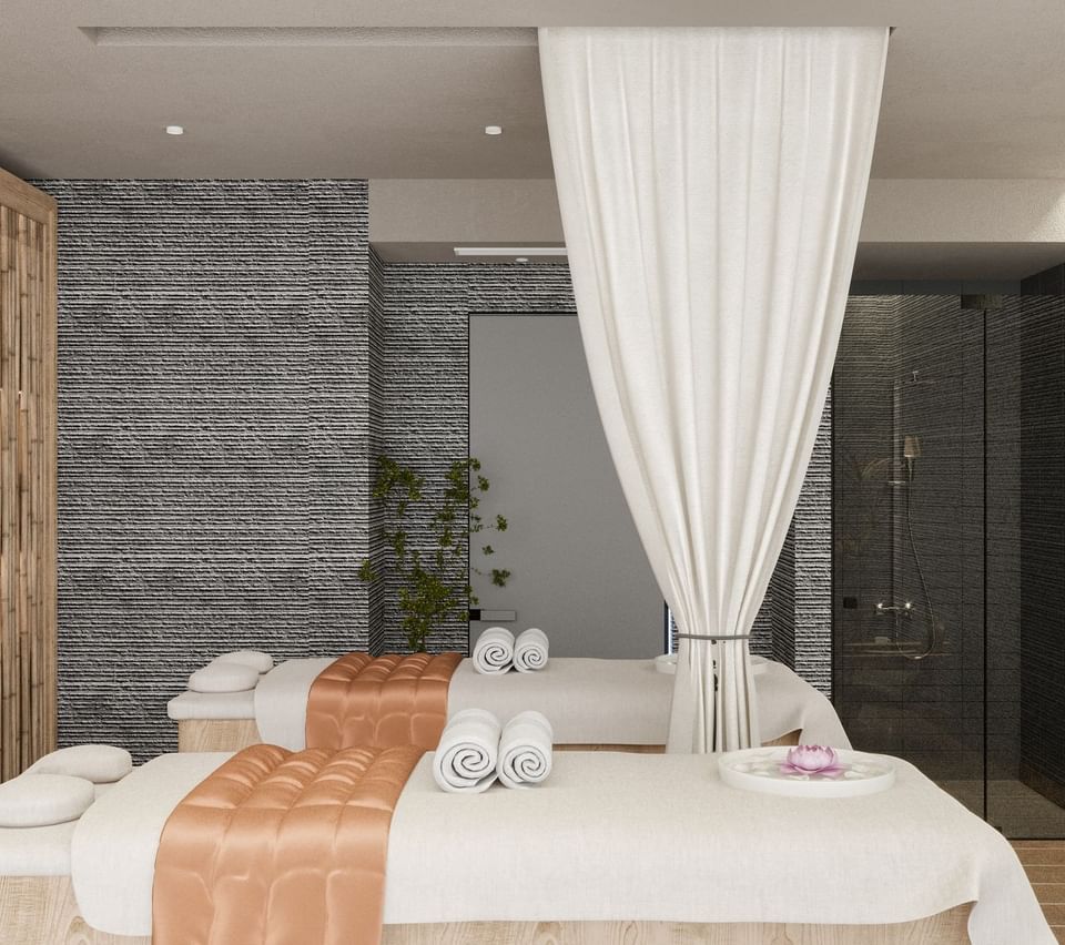 Spa room of The LifeCo Wellness Center, with two massage tables, sheer curtains, and a luxurious ambiance at A'ila Resorts