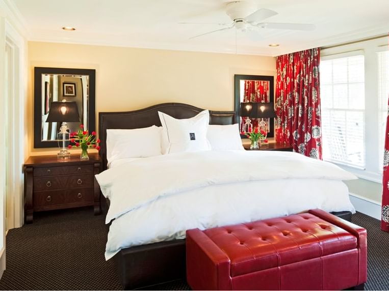 The Tenant House Down room with comfy bed, red curtains, and a leather bench in Inn at Willow Grove