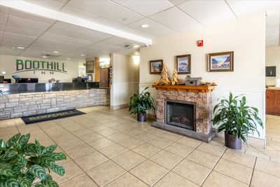 Front desk & fireplace by the lobby area at Boothill Inn & Suites