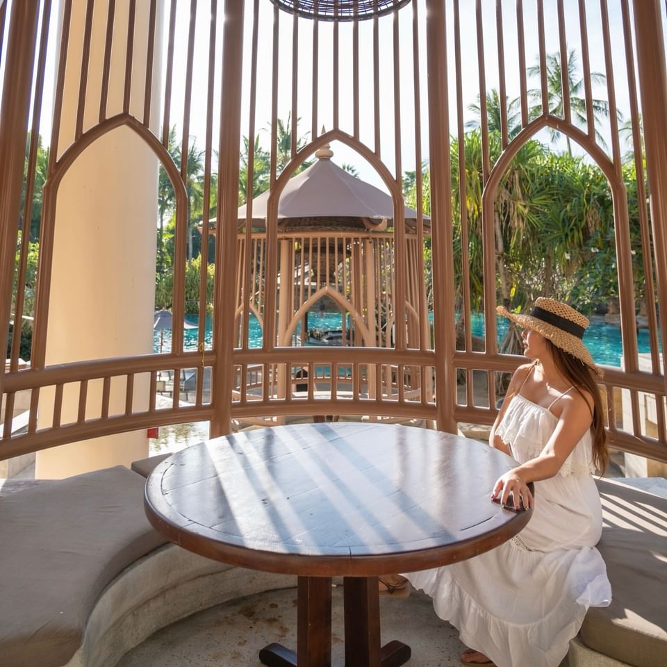 A lady enjoying a tropical view under a cabana