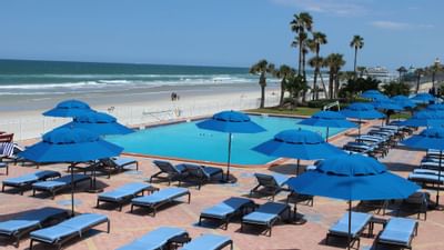 blue lounge chairs and umbrellas by the pool