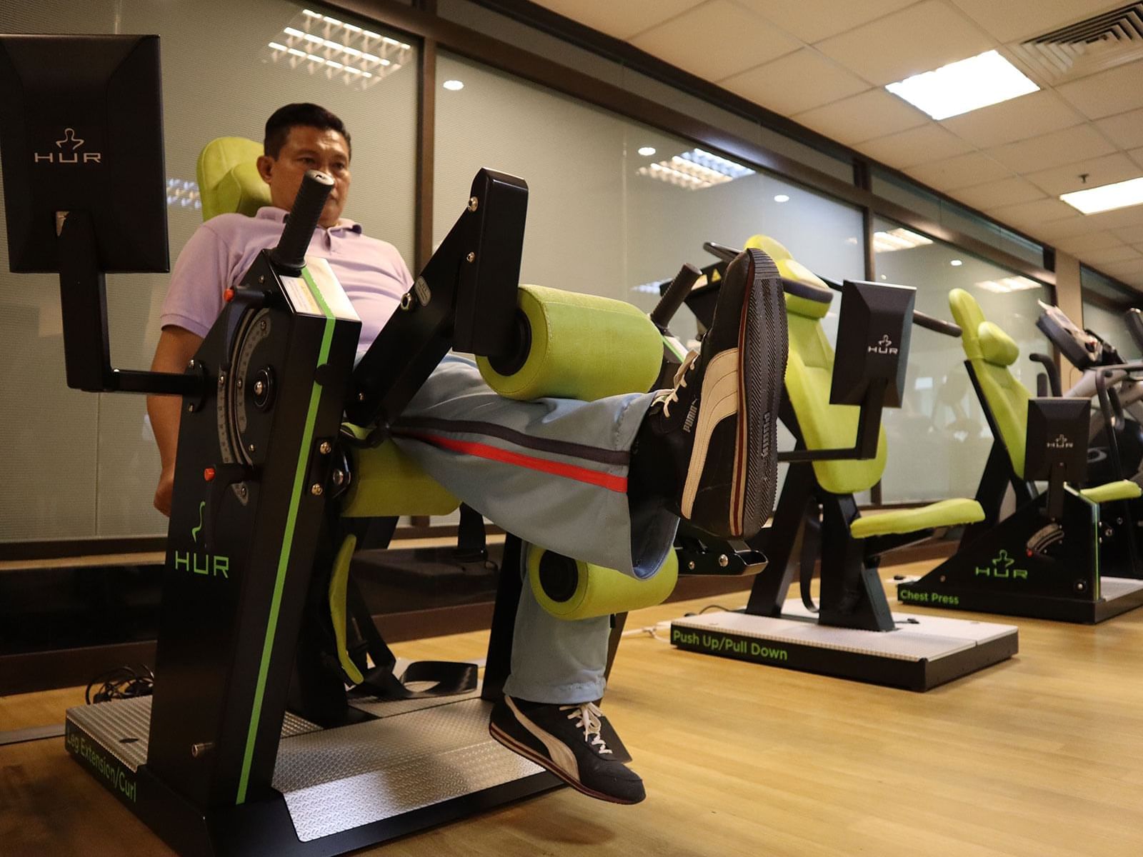 A man working out on a gym machine in a Gym wellness center at MiCasa All Suite Hotel KL