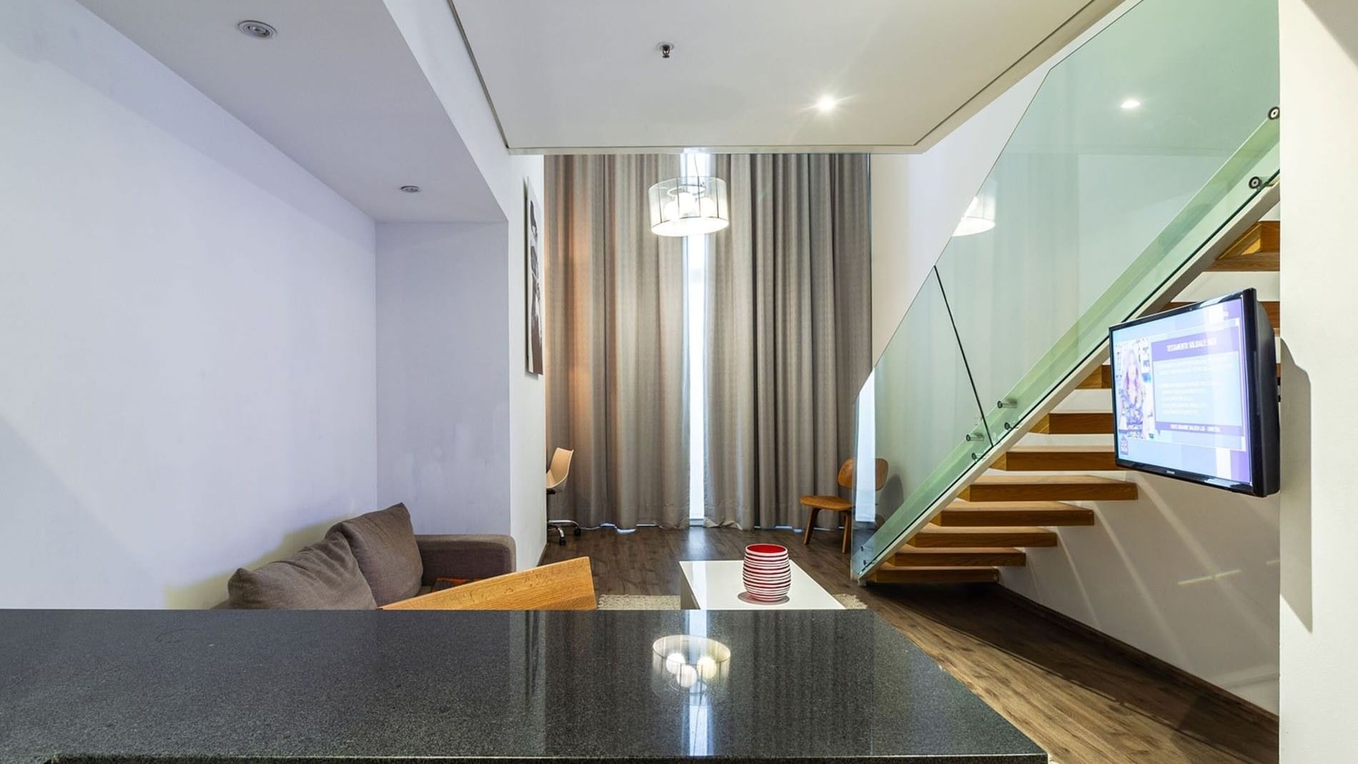 Queen Loft Bed at Camino Real Puebla Angelopolis featuring a wooden staircase and a wall-mounted TV