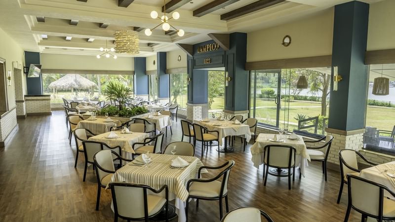 Spacious restaurant featuring elegant tables set with large windows at Fiesta Inn Tampico