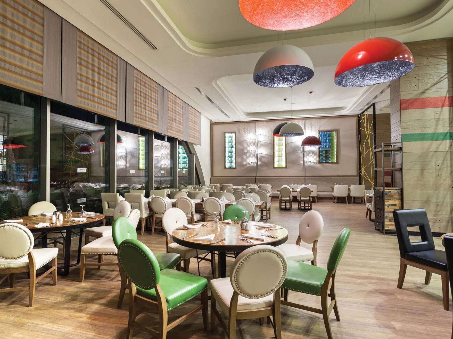 Dining tables arranged with chairs in Parkfora Main Restaurant at Titanic Deluxe Lara