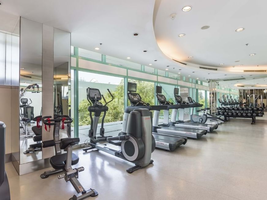 Interior of the gym with the outdoor view at Chatrium Hotel