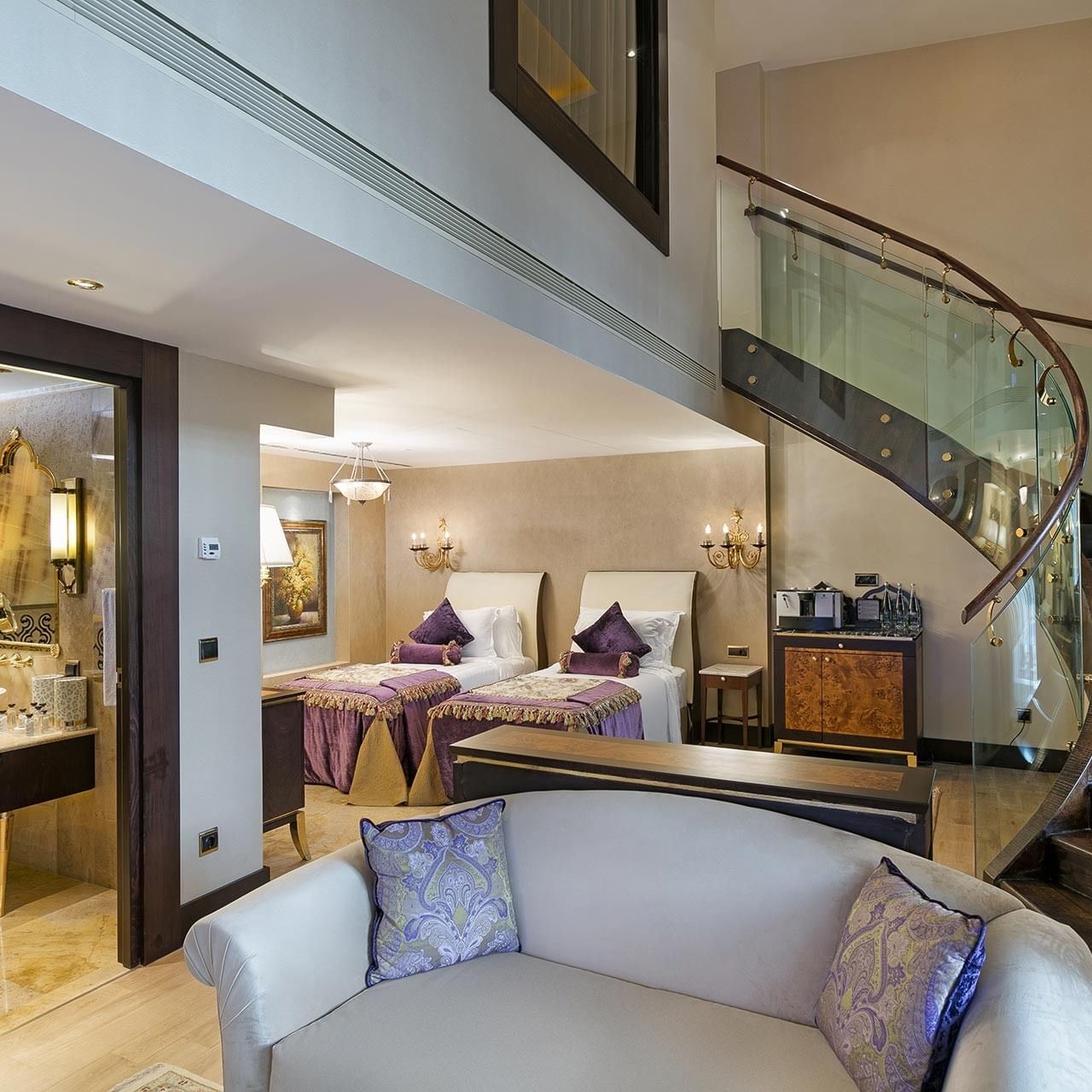 Pool Duplex Suite at Titanic Mardan Palace with a spiral staircase, white couch, and two beds with purple and white pillows.