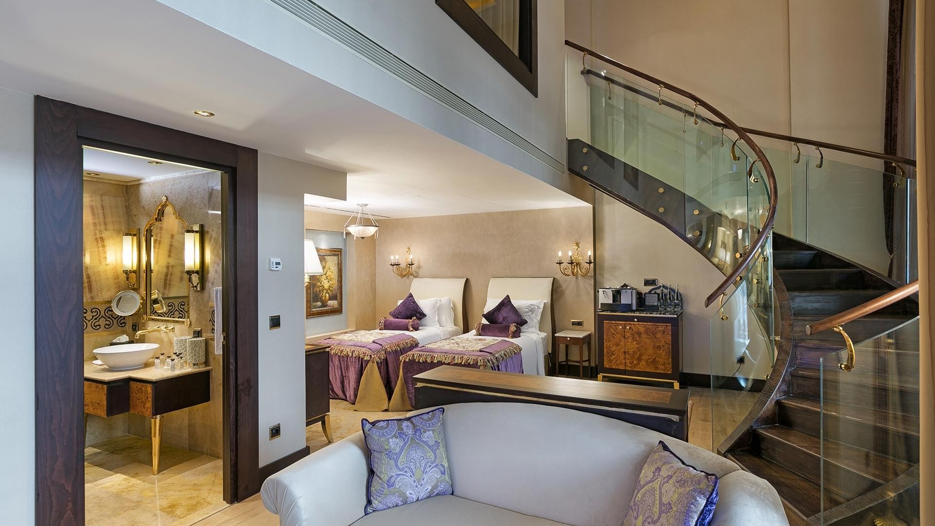 Pool Duplex Suite at Titanic Mardan Palace with a spiral staircase, white couch, and two beds with purple and white pillows.