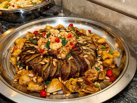Roasted vegetables with meat and pine nuts on a platter at Warwick Doha in Doha.