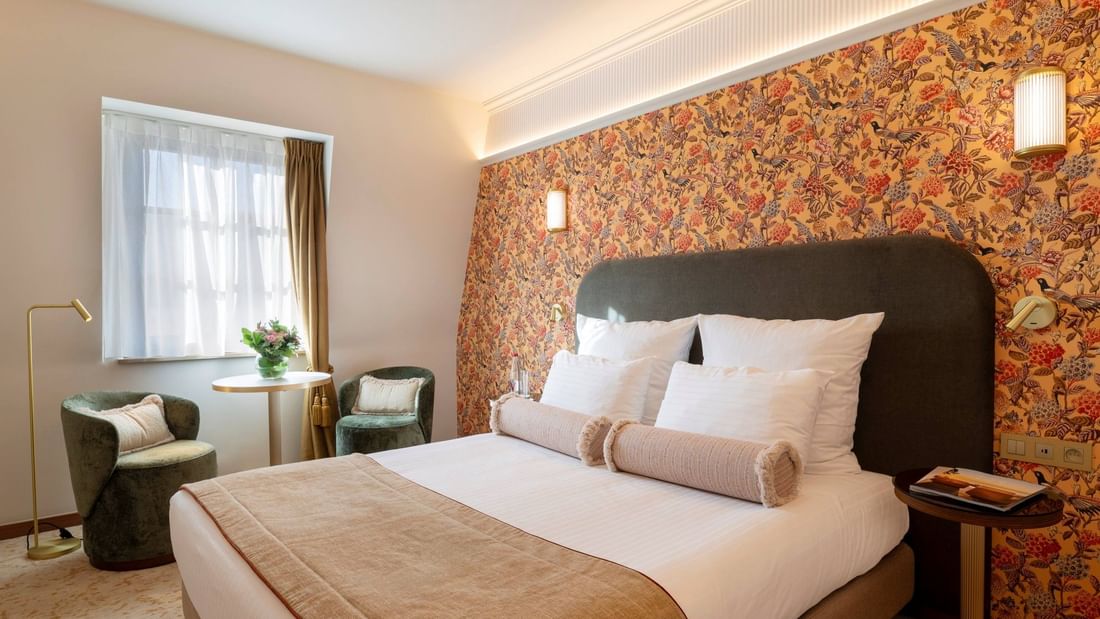 Classic Room with floral accent wall, plush bedding, and seating area at Warwick Brussels Grand-Place in Brussels