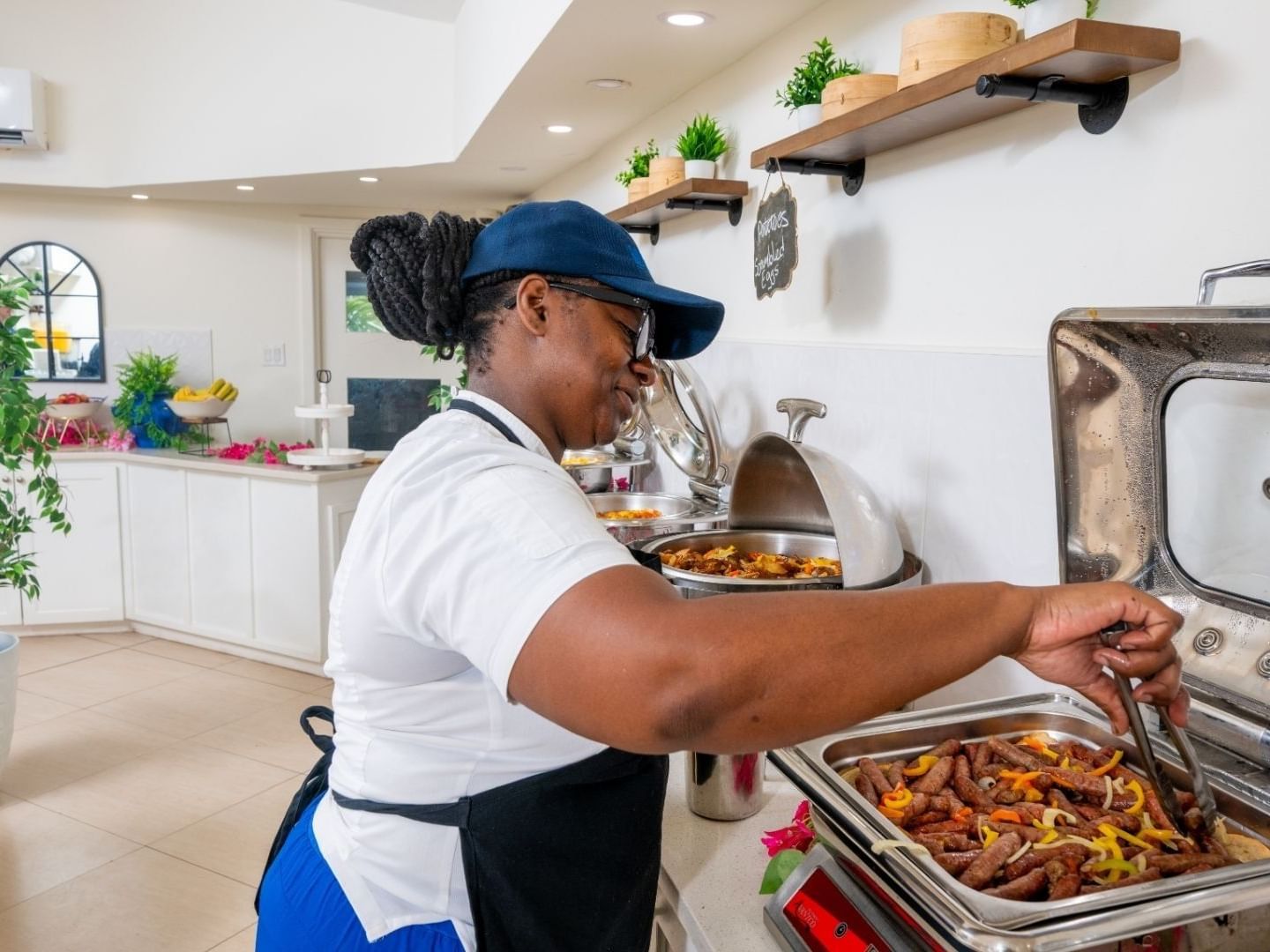 Woman in chef's hat and apron preparing food at the Savannah Beach Hotel.