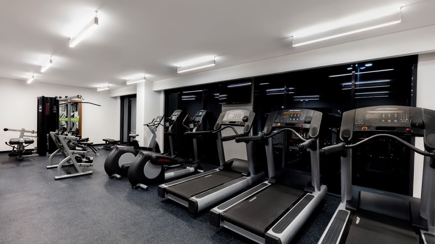 Gimnasio en el Fiesta Inn Express Cancún Cumbres con cintas de correr colocadas junto a una ventana