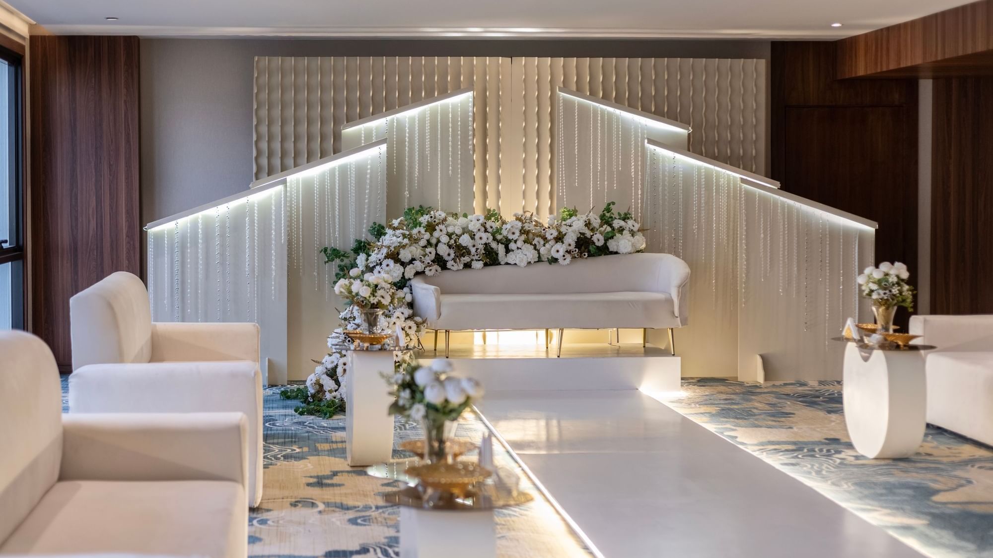 Elegant indoor wedding setup with a white runway, flanked by cream chairs in Amarige Hall at Warwick Hotels and Resorts