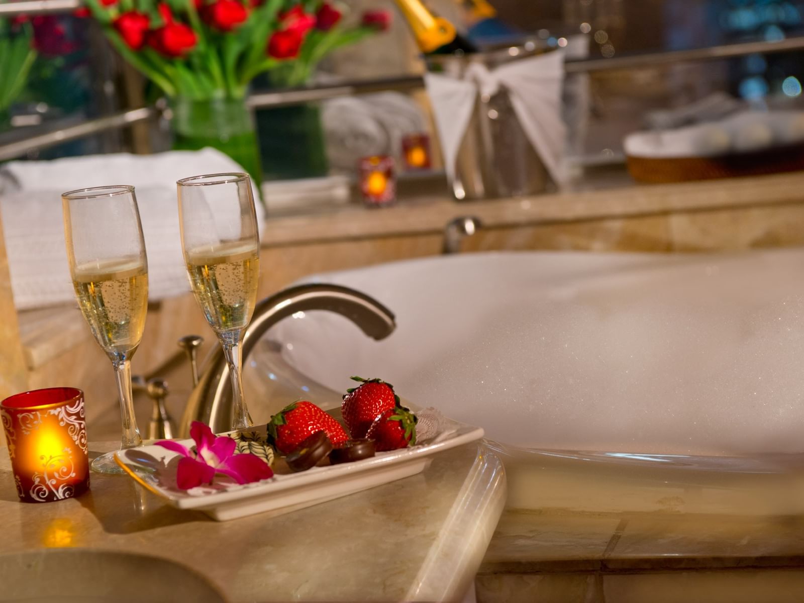 Champagne glasses & strawberries on edge beside warm Jacuzzi bubble bath room in Executive Guestroom at The Kimberly Hotel