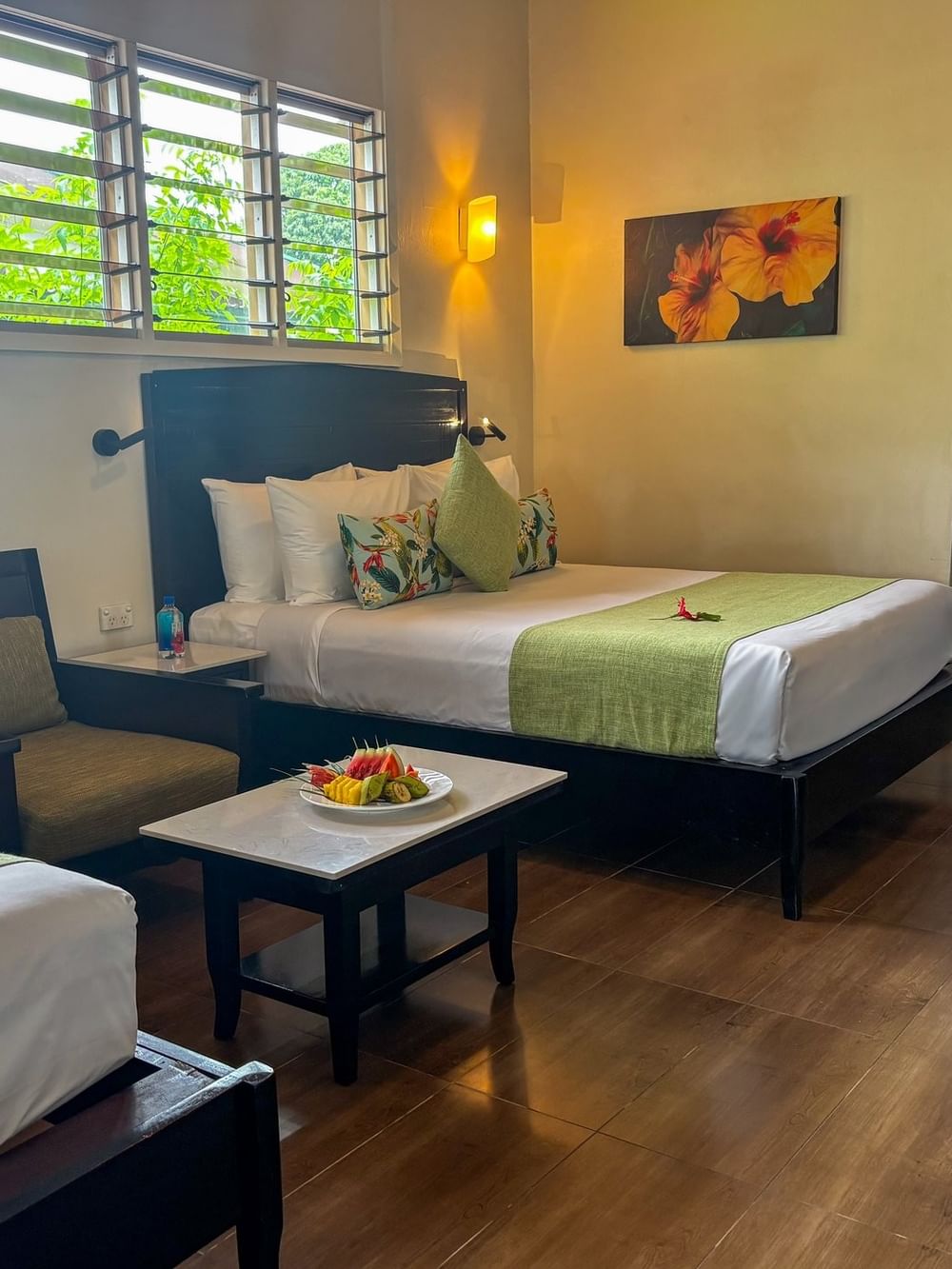 King bed and twin bed with lime runners by a fruit platter and armchair in Studio Villa at TokaToka Resort Nadi Fiji