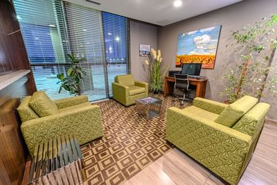 Working desk and comfy chairs in the lobby area of Encore Suites Grande Prairie
