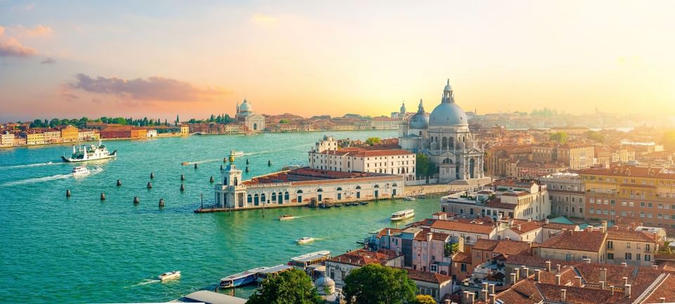 Panoramic aerial view of Grand Canal and Basilica di Santa Maria della Salute during bright sunset near Meraviglia