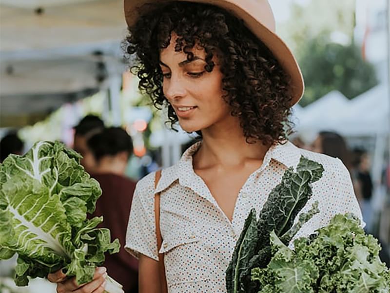 mujer escogiendo verduras frescas