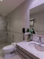 Granite vanity by a white toilet & a glass shower with a towel on handle in Junior Suite City View at Warwick Al Jubail
