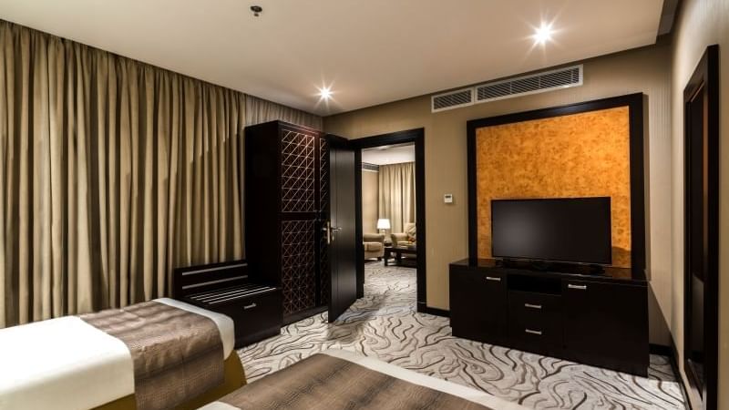 Spacious Junior Suite with twin beds and a separate seating area at Warwick Hotels and Resorts, with modern decor