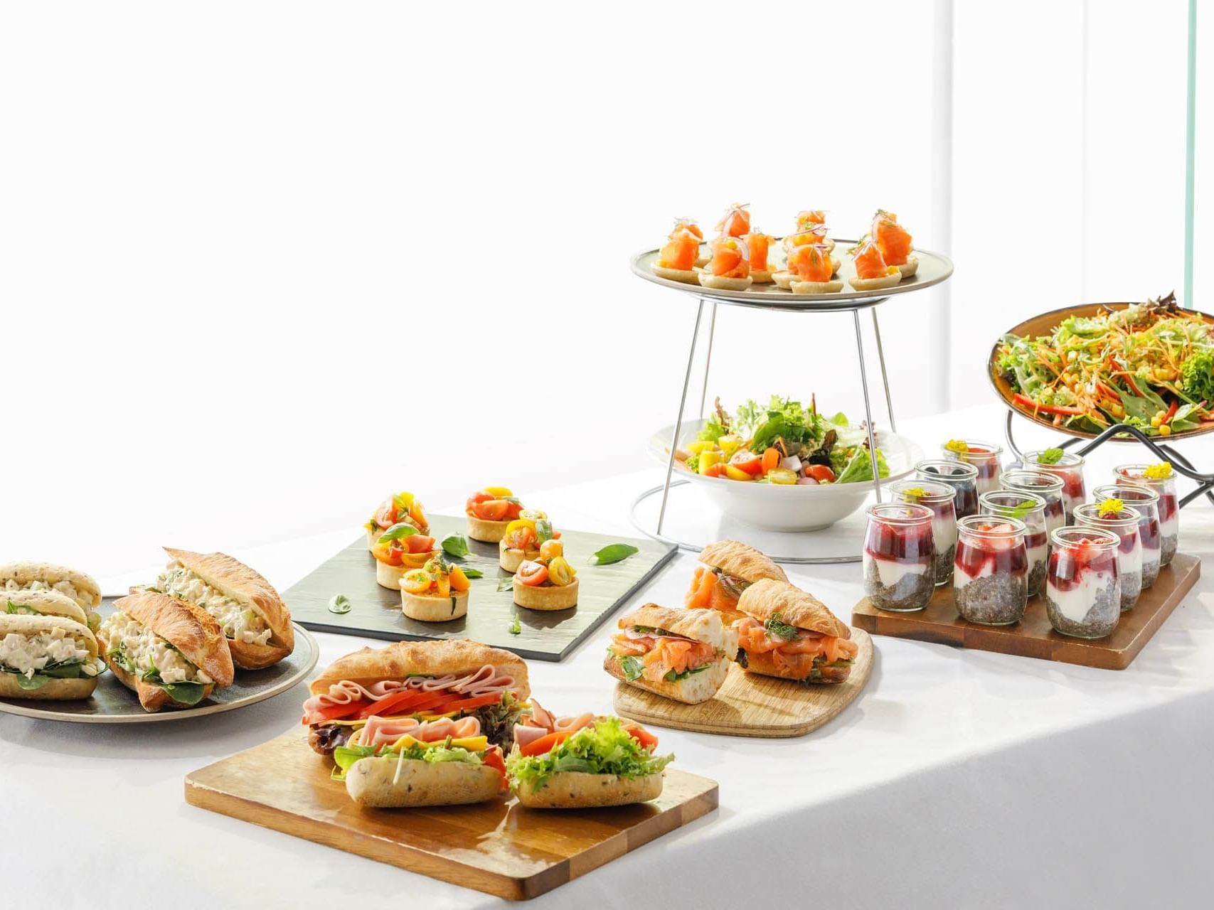 Club sandwiches, salad & mini desserts on a table at Grand Chancellor Melbourne