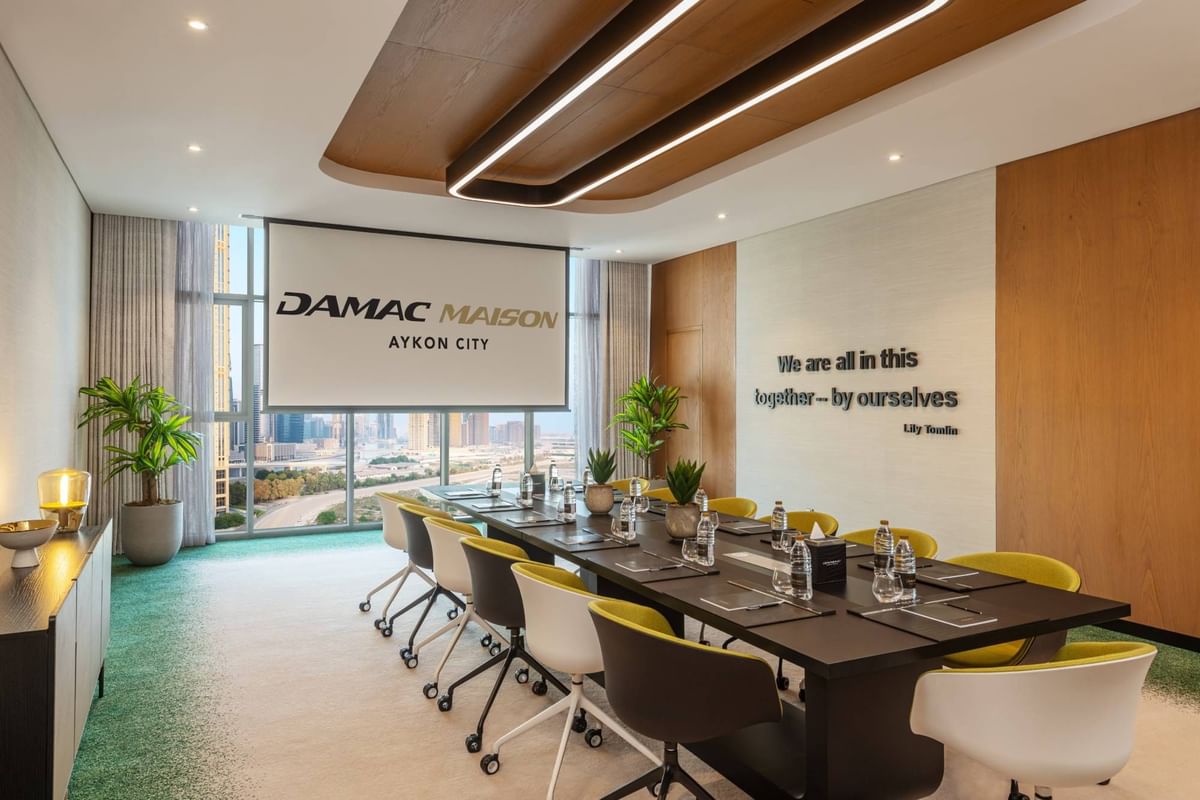 Executive Meeting Room with long table with chairs, city views, sleek design, and meeting setup at DAMAC Maison Aykon City