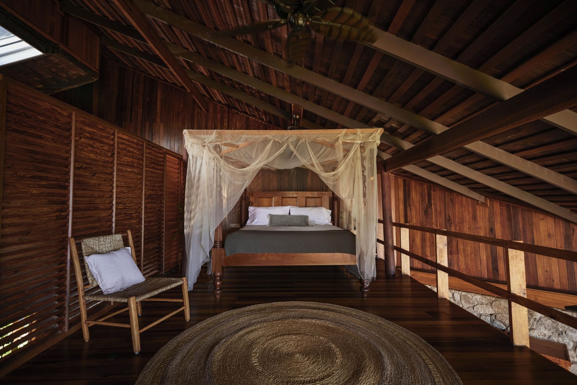 King-size bed and a chair on a wooden finished stair in Heritage Suites at Ladera Resort