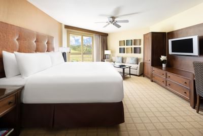 King bed room with a large bed, couch, TV, and a view of the mountains at Elevation Resort & Spa.