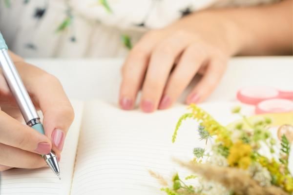 Bride to be writing down questions to ask potential wedding venues