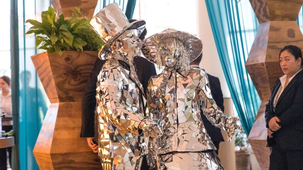 Two performers in dazzling mirrored costumes entertaining guests at The Ternary in Novotel Sydney on Darling Harbour
